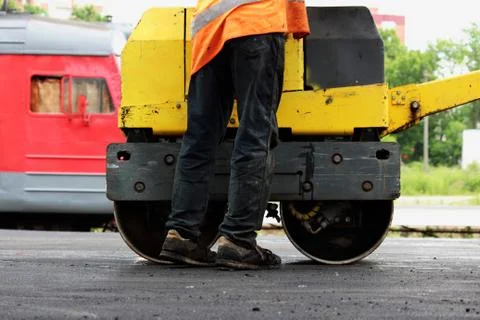 A small compactor covers with asphalt to platform at the railway station. The Foto stock