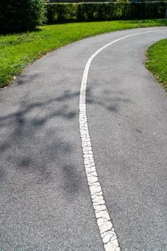 Small concrete path in the middle of meadow Stock Photos