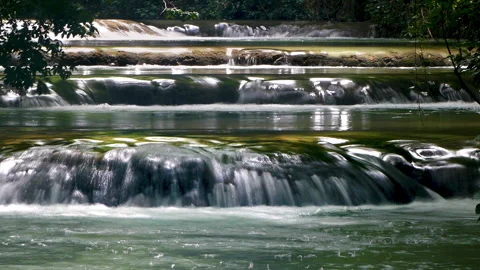 Small consecutive waterfalls that flow in an idyllic place. Silk effect. Stock Footage 287495335