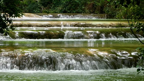 Small consecutive waterfalls that flow in an idyllic place. 4k. Sound available Video stock 287495455
