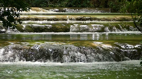 Small consecutive waterfalls that flow in an idyllic place. Slow Motion. Stock Footage 287498164