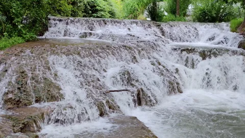 Small consecutive waterfalls that flow in an idyllic place. Stock Footage 303562167