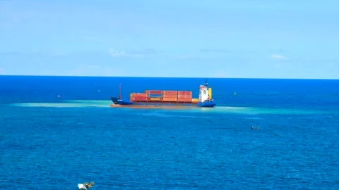 Small container ship run aground and use engine to salvage itself Stock Footage 155014313