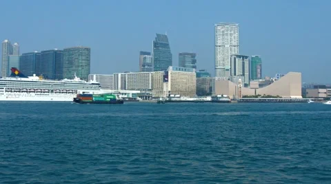 Small container ship transiting the bay beneath the highrise buildings Video stock 57229423