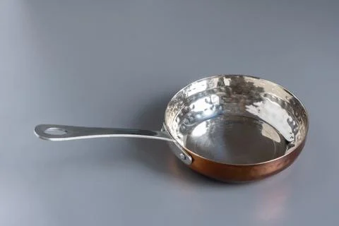 Small copper pan on a gray background. View with copy space. Stock Photos