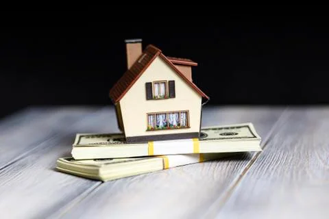 A small copy of the house is in dollars. Stock Photos