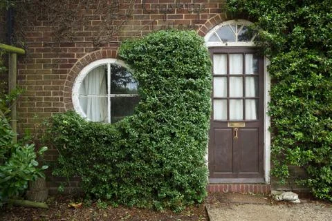 Small cottage with round window and front door UK Stock Photos