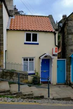 Small cottage situated between two large buildings in Robin Hoods Bay, North Stock Photos