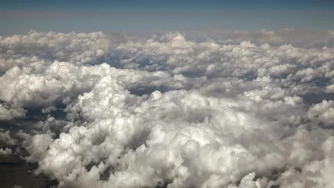 Small cotton clouds seen from plane window in bright sky - Layered Atmosphere Stock Footage 339726219