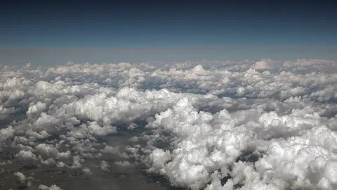 Small cotton clouds seen from plane window in bright sky during an aerial flight Stock Footage 339726274