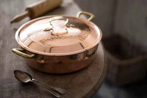 Small Covered Copper Pot on Edge of Wooden Counter Stock Photos