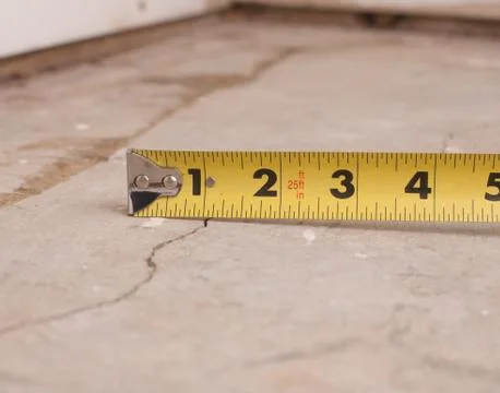 Small crack in cement foundation with tape measure Stock Photos