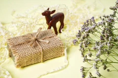 Small craft gift box rustic style on light yellow background with dry flowers Stock Photos