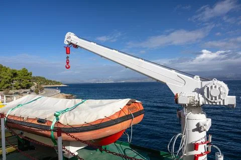 A small crane on a ship used to lower a lifeboat. Stock Photos