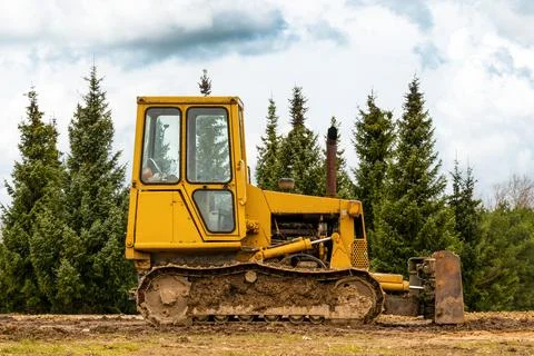 Small crawler bulldozer left on the construction site Stock Photos
