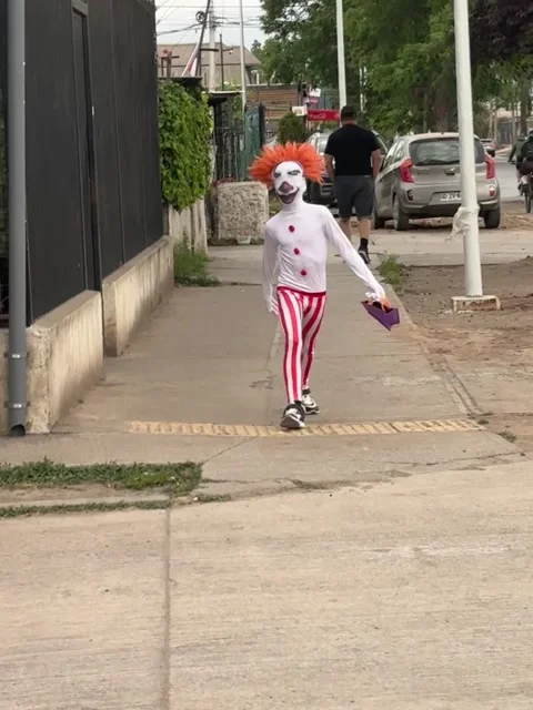 Small Creepy Clown Skips Down Street, Renca, Santiago, Chile - 31 Oct 2025 Stock Footage 320504372