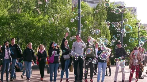 SMALL CROWD WATCHING BUBBLE BLOWING LONDON ENGLAND Stock Footage 72976343