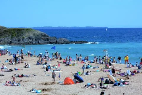 Small crowded beach by the ocean Stock Photos