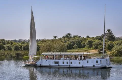 Small crusing ship close to the bank on the river Nile Stock Photos