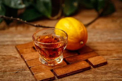 Small cup of brandy and lemon with candle Stock Photos