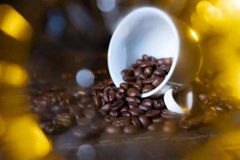 Small cup full of coffee beans on an old wooden table Stock Photos