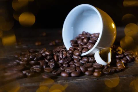 Small cup full of coffee beans on an old wooden table Stock Photos