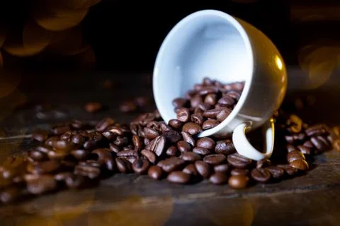 Small cup full of coffee beans on an old wooden table Stock Photos