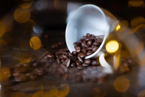 Small cup full of coffee beans on an old wooden table Stock Photos