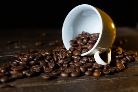 Small cup full of coffee beans on an old wooden table Stock Photos
