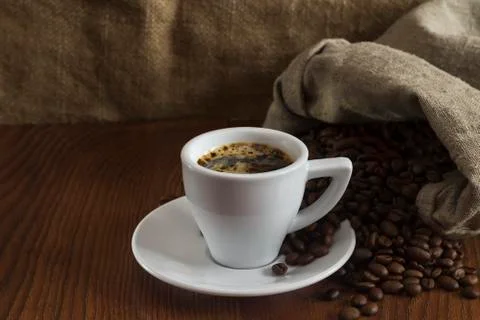 A small cup of hot coffee on a table with coffee beans Stock Photos
