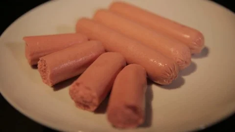 Small cut sausages lie on a white plate, close-up Stock Footage 75259385