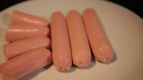 Small cut sausages lie on a white plate Stock Footage 75259435