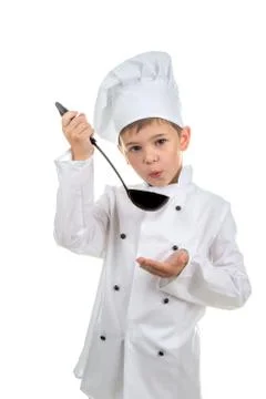 Small cute boy in chef's hat with ladle tastes the cooked soup Stock-Fotos