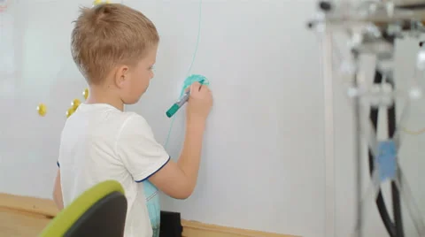 Small, cute boy draws markers flowers on the wall Stock Footage 39312284