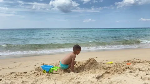 Small cute boy playing at the beach with sand and toys Stock Footage 277603314