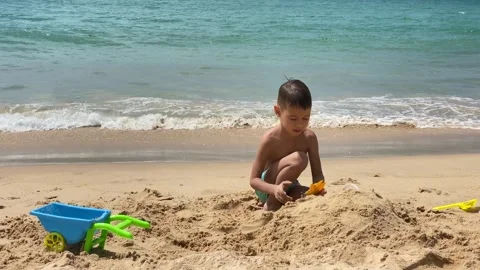 Small cute boy playing at the beach with sand and toys Stock Footage 277603577