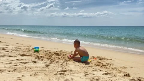 Small cute boy playing at the beach with sand and toys Stock Footage 277603832