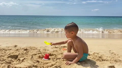 Small cute boy playing at the beach with sand and toys Stock Footage 277604210