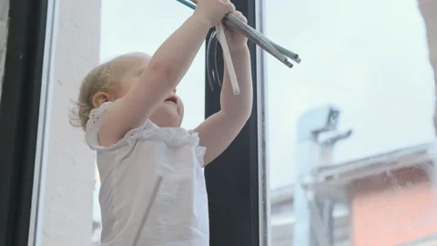 Small cute child in white t-shirt plays with colorful sticks near window. Happy Stock Footage 142483484