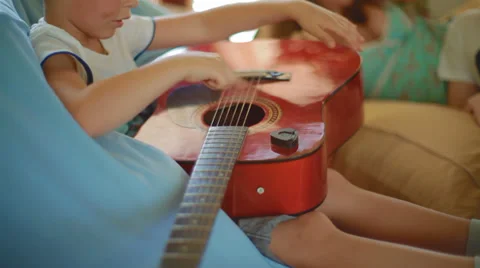 Small, cute, creative boy learning to play acoustic guitar Stock Footage 39311550