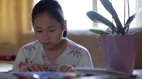 Small cute focused girl reading a book at home. Doing homework after school Stock Footage