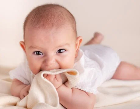 Small cute funny baby infant teething with face expression hands and fingers  Stock Photos