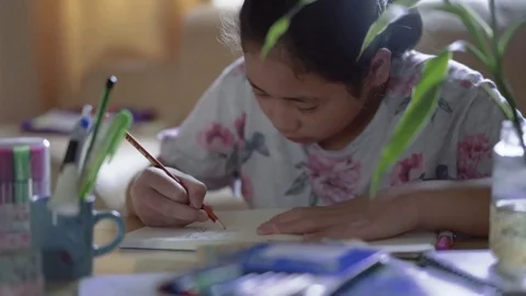 Small cute school girl doing homework at home. Holding pencil thinking Stock Footage 80638116