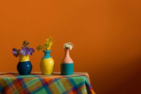 Small cute tiny vases with mini bouquet of spring flowers. Warm bright yellow Stock Photos