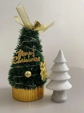 Small cute white ceramic and green Christmas tree on the table Stock Photos