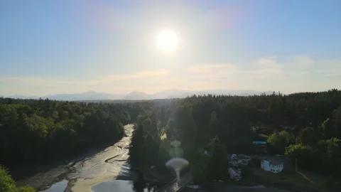 Small dam, distant mountains, green trees, small low tide river creek, sunset Stock Footage 155725205