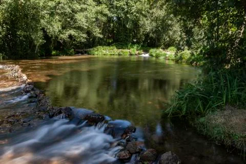 Small dam in the middle of the forest with two small waterfalls. Stock Photos