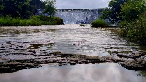 Small Dam Overflow Creating Water Ripples in Pond in Slow Motion Stock Footage 327998444