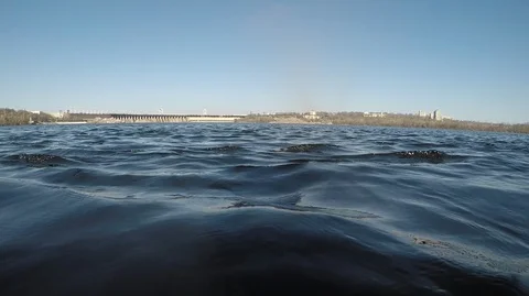 Small dark blue waves on the river smoothly find ashore, clear sky clear day, Stock Footage 127429506