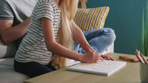 Small Daughter Is Drawing While Father Is Busy with His Gadget Stock Footage 133376504